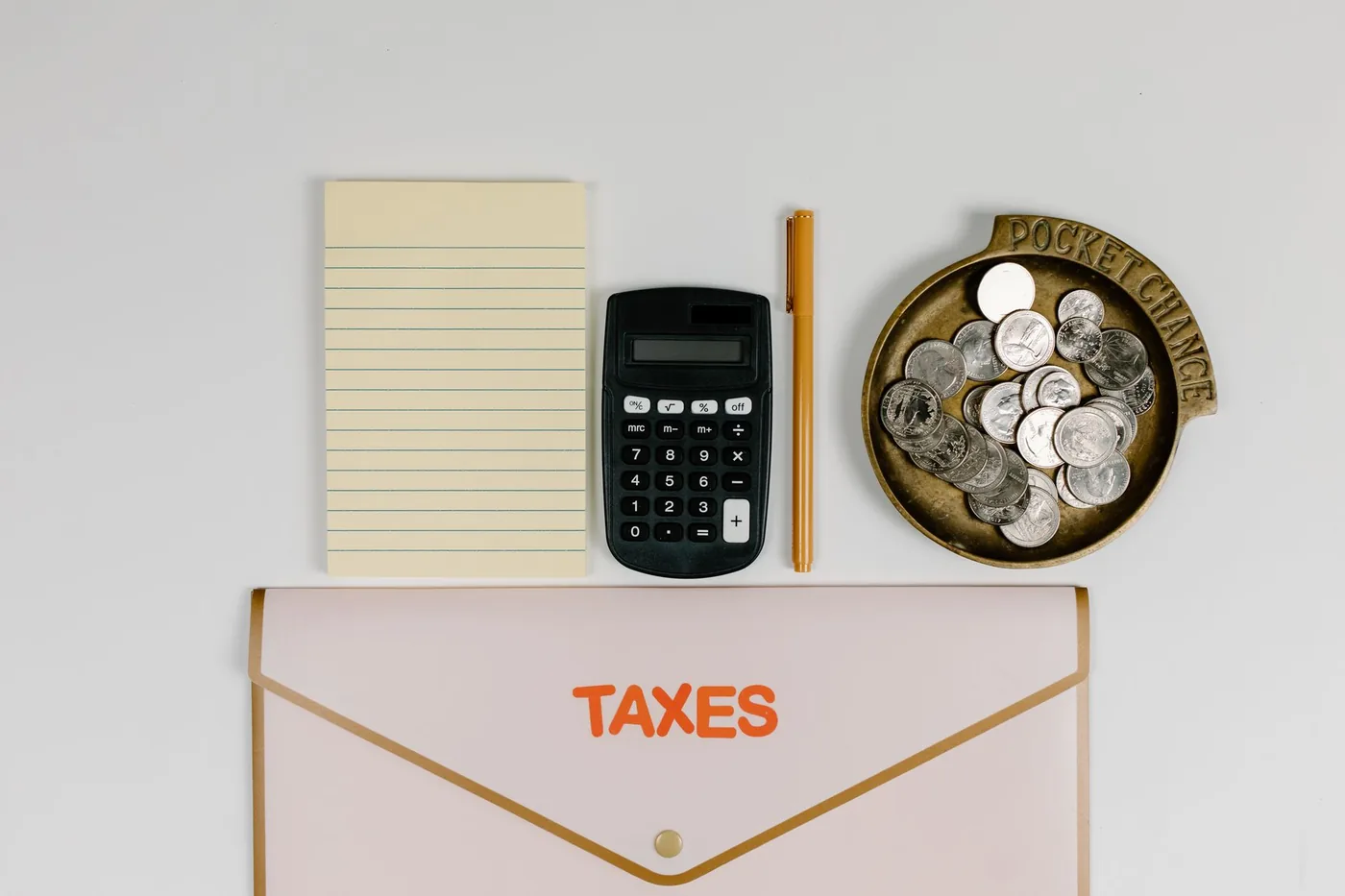 Obálka s nápisem Taxes, kalkulačka a mince