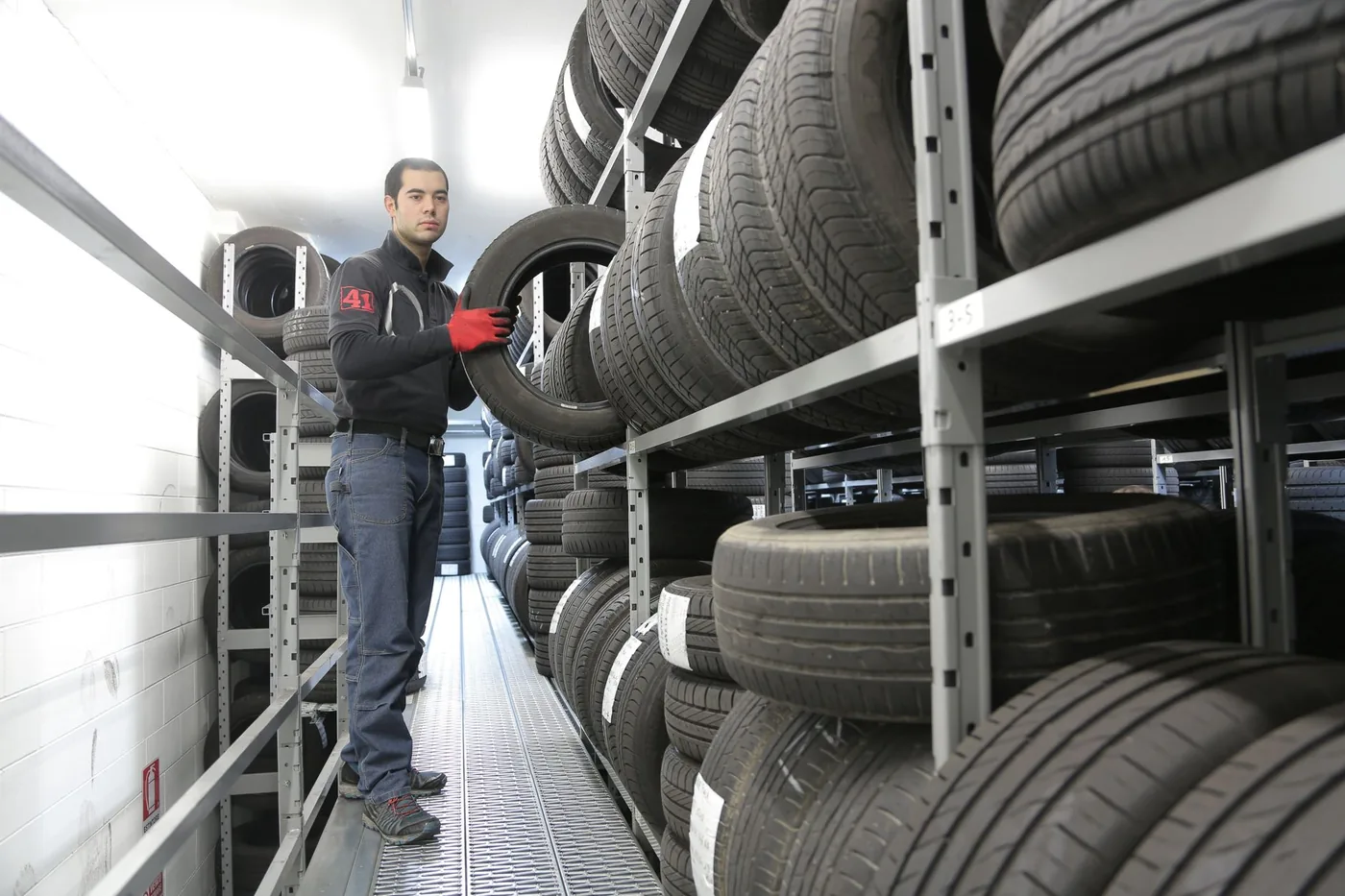 mechanik vybírá pneumatiku ve skladu