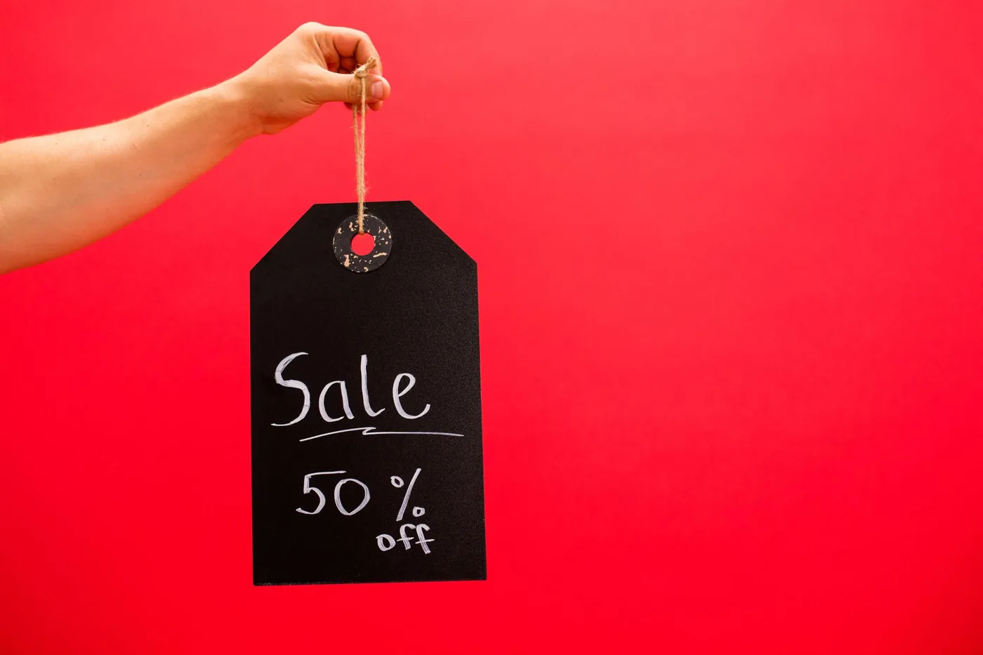 ruka drží černou cedulku Sale 50% off